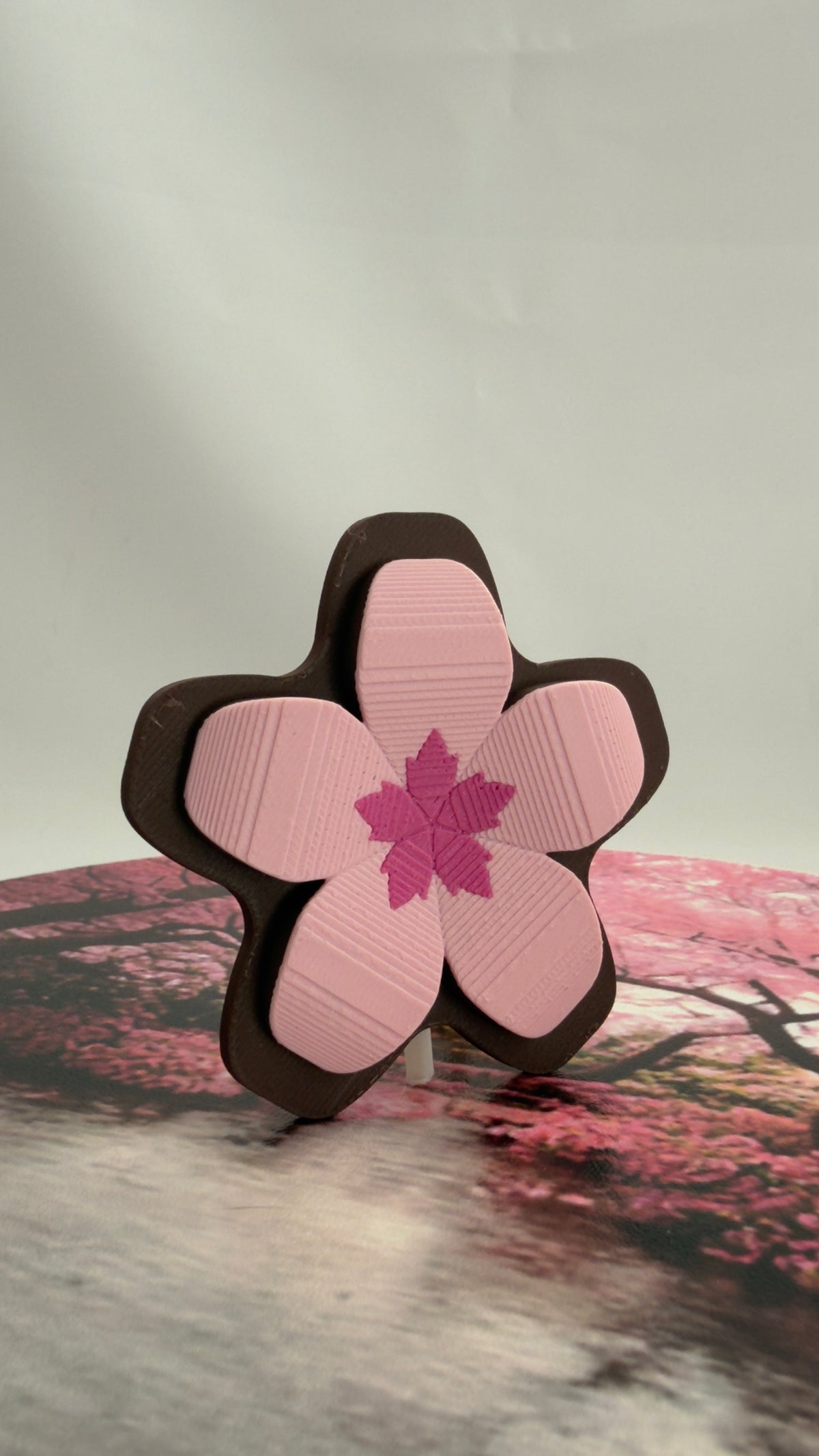 A Sakura flower decorative object for keycard retractors.